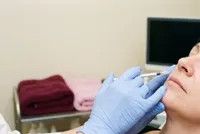 Yanağa yaklaştırılan ince şırınga